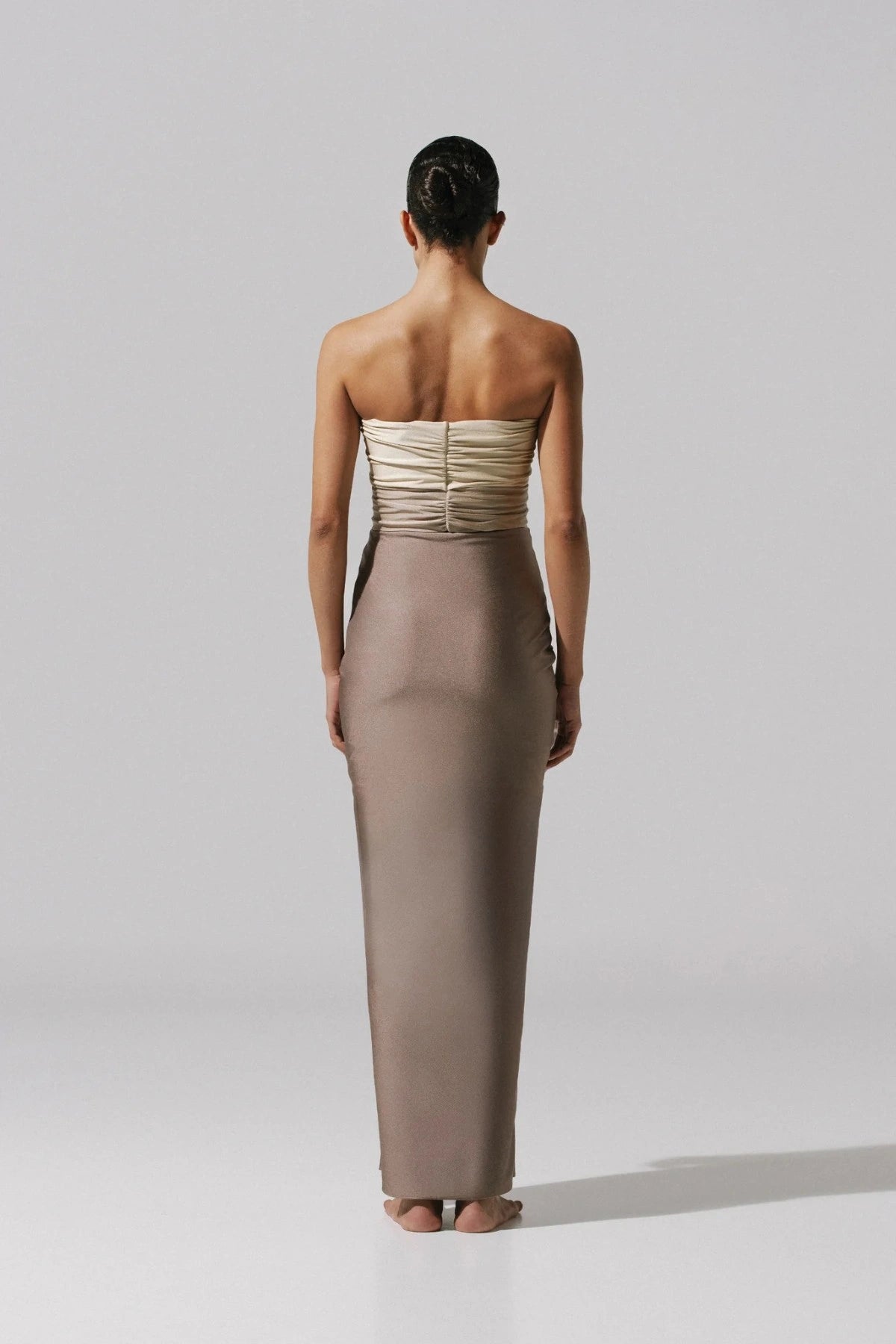 Giselle Maxi Dress by Baobab, a strapless gown with knot drape and front slit. Finished with a cascading hem and sculptural shape.