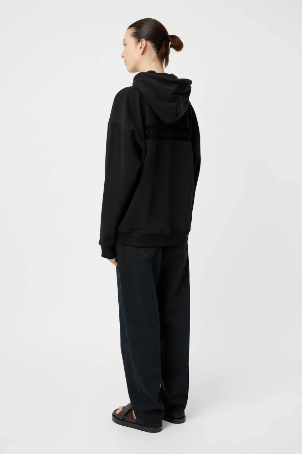 Grid Flocking Logo Hoodie Black by Camilla and Marc – Oversized fit with lined hood, flat drawcord, ribbed cuffs and hem, twin needle stitching, and subtle toothbrush flocked logo.