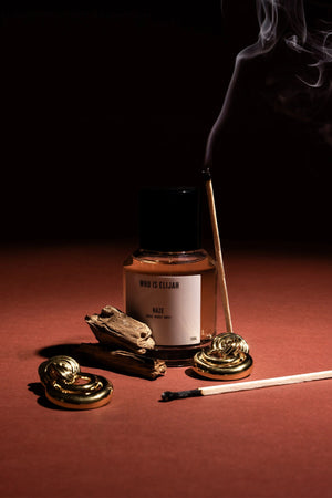 Haze by Who Is Elijah, a unisex scent with pink pepper, orange blossom, clove, chestnut, cedarwood, vanilla, and warm woods.