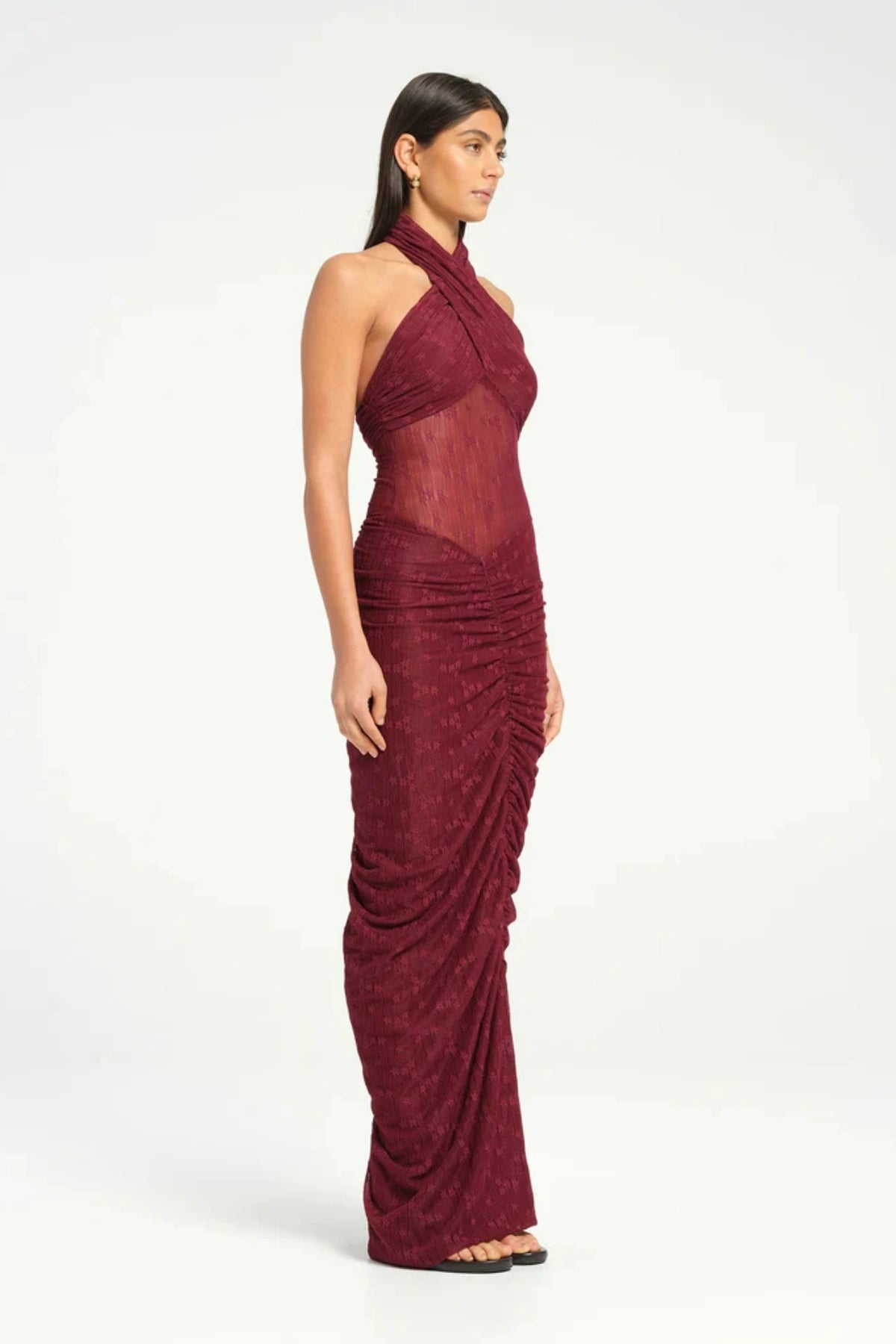 Hudson Lace Maxi Dress Sangria by Benni, sensual stretch lace with twist halter neckline, ruched seams, sheer waist panel for a bold evening look.