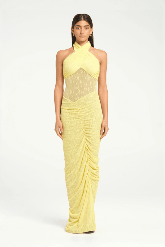 Hudson Lace Maxi Dress Butter by Benni, elegant stretch lace dress with twist halter neck, ruched seams, and sheer waist panel for a bold evening look.