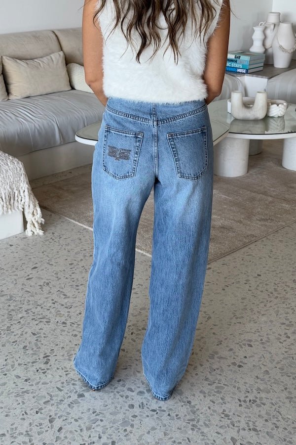 Stella High Rise Straight Leg Light Blue by Sneaky Link, classic high-waist jeans with a straight leg silhouette. Made from 100% cotton with signature SL Snake embroidery. Rigid fit; size up if between sizes. Cold delicate wash.