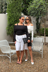 Jaz Layered Long Sleeve Top in Black with a soft off shoulder layered neckline and fitted long sleeves, creating a smooth, sculpted silhouette with a clean, modern edge.