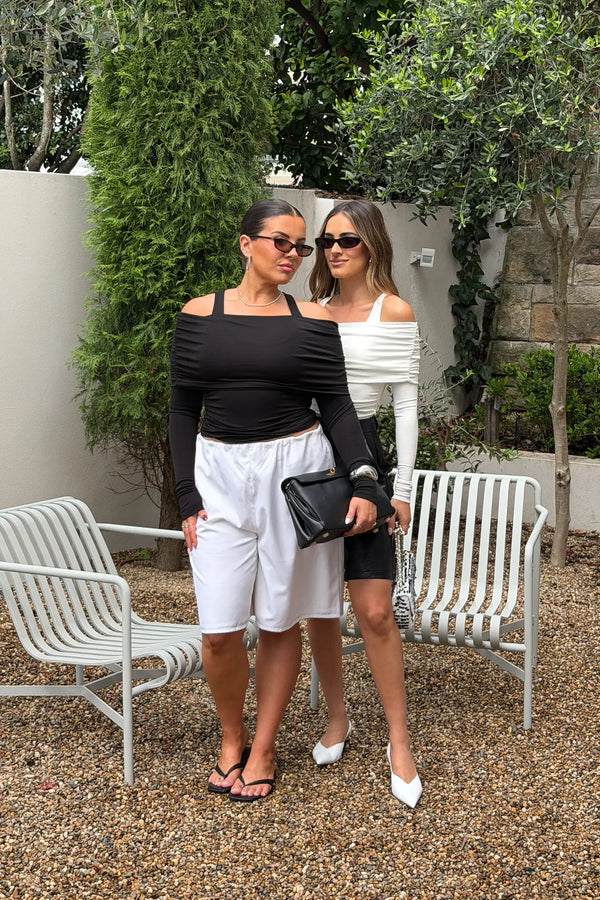 Jaz Layered Long Sleeve Top in Black with a soft off shoulder layered neckline and fitted long sleeves, creating a smooth, sculpted silhouette with a clean, modern edge.