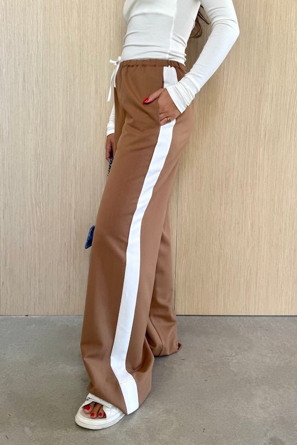 Denver Pant Tan by Sneaky Link, relaxed fit with elastic waist, contrast side stripe, and drawstring for a sporty look. Made from polyester blend. Cold hand wash. Size down if between sizes.