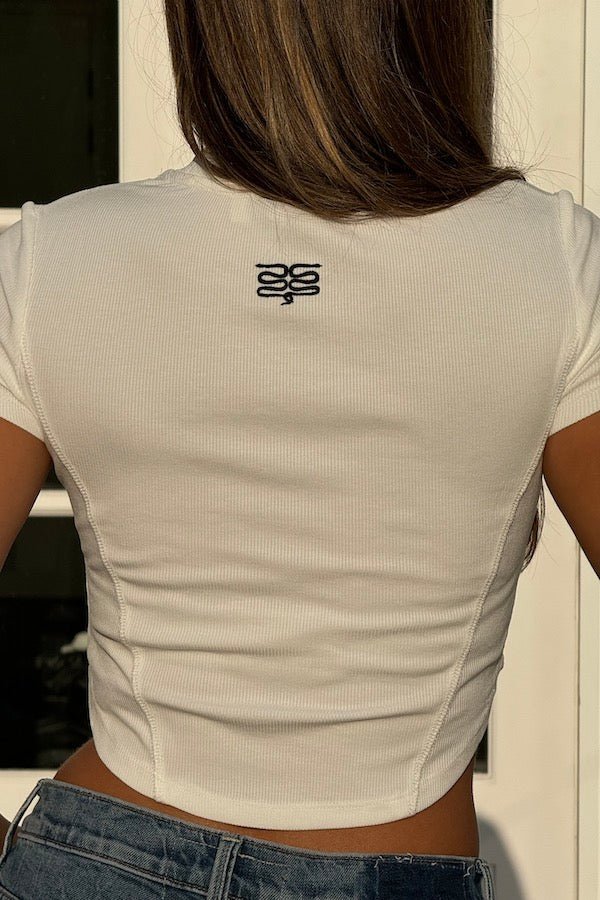 Baby Tee White by Sneaky Link – Cropped viscose-spandex ribbed tee with iconic embroidered snake at the back neck, a versatile staple perfect for pairing with cargo or Aspen pants for a fresh, effortless look.
