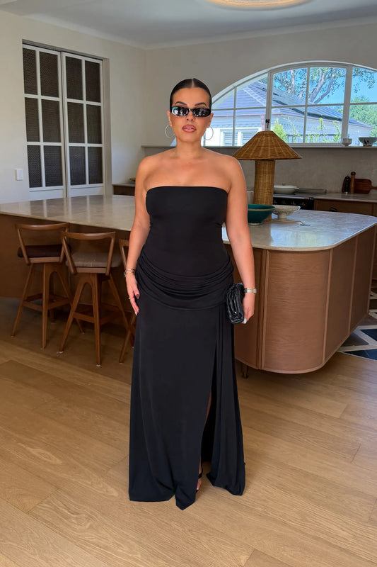 Black strapless maxi dress with a thigh-high split and flowing skirt, styled on a mannequin.