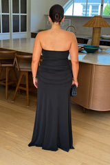 Black strapless maxi dress with a thigh-high split and flowing skirt, styled on a mannequin.