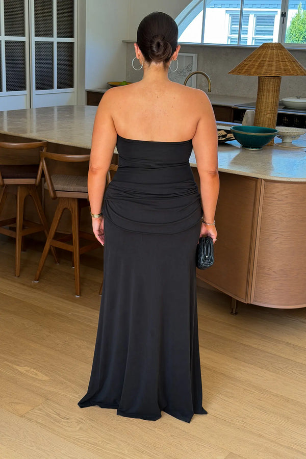 Black strapless maxi dress with a thigh-high split and flowing skirt, styled on a mannequin.