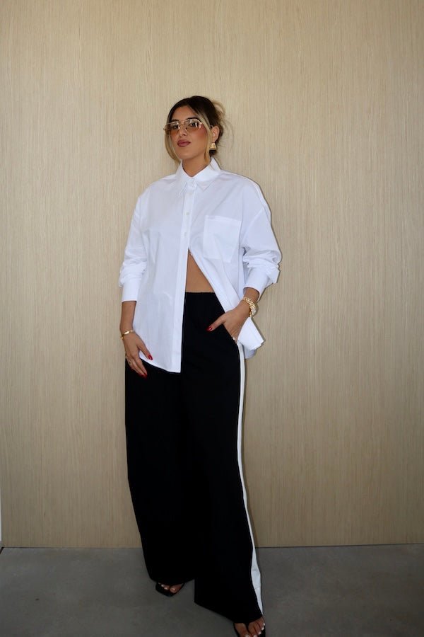 Boston Shirt White by Sneaky Link – Crisp oversized cotton poplin with button front and signature snake embroidery. Perfect for viral classic and casual-chic looks.