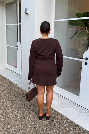 Jaz Long Sleeve Knot Mini Dress in Chocolate with a soft front knot, sculpted waist, and gentle ruching that creates a smooth, body hugging silhouette in a rich, elevated finish.