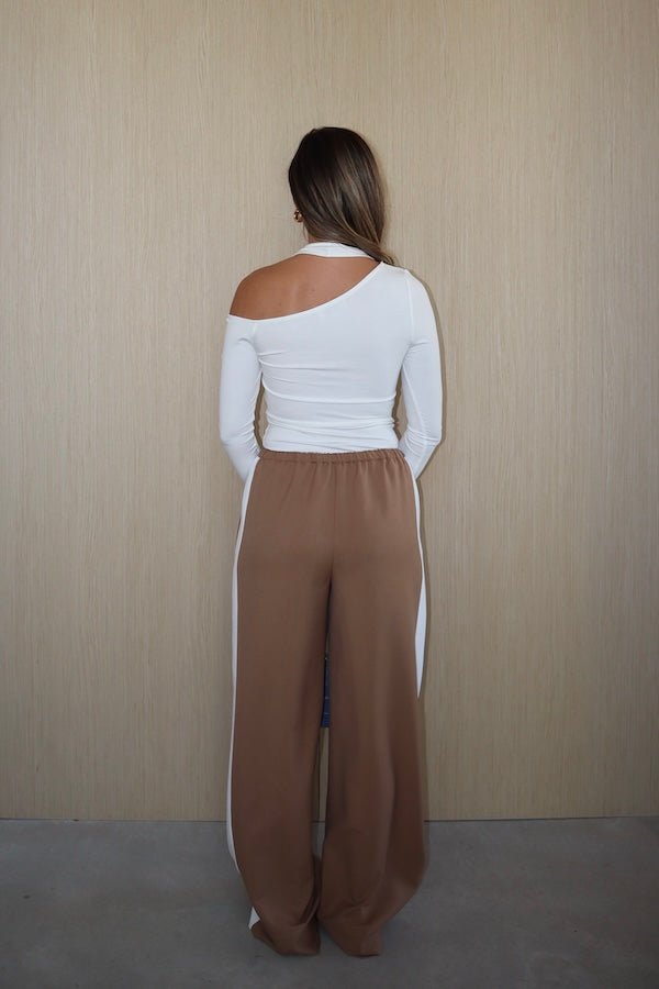 Denver Pant Tan by Sneaky Link, relaxed fit with elastic waist, contrast side stripe, and drawstring for a sporty look. Made from polyester blend. Cold hand wash. Size down if between sizes.