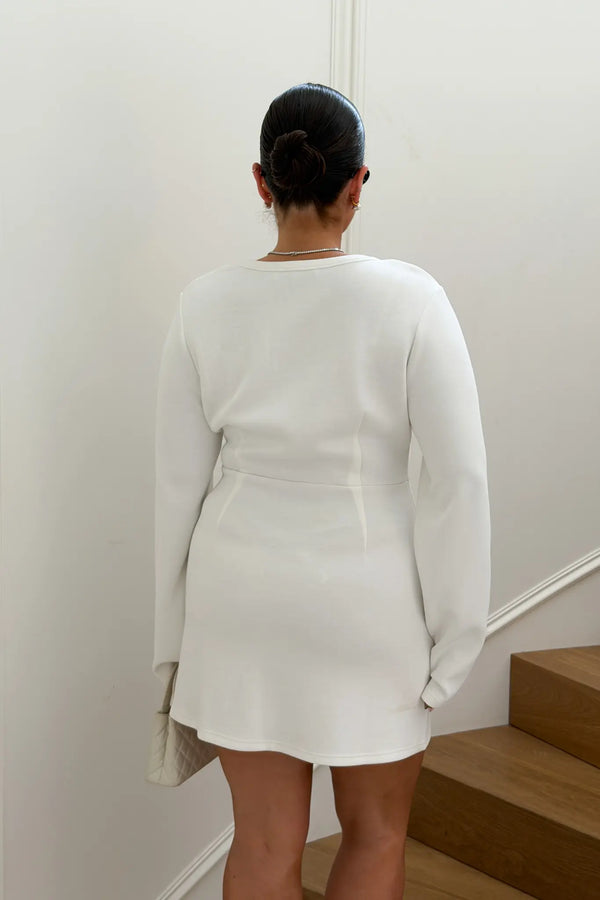 Jaz Long Sleeve Knot Mini Dress in White with a soft front knot, sculpted waist, and gentle ruching that creates a smooth, body hugging silhouette with a clean, elevated finish.