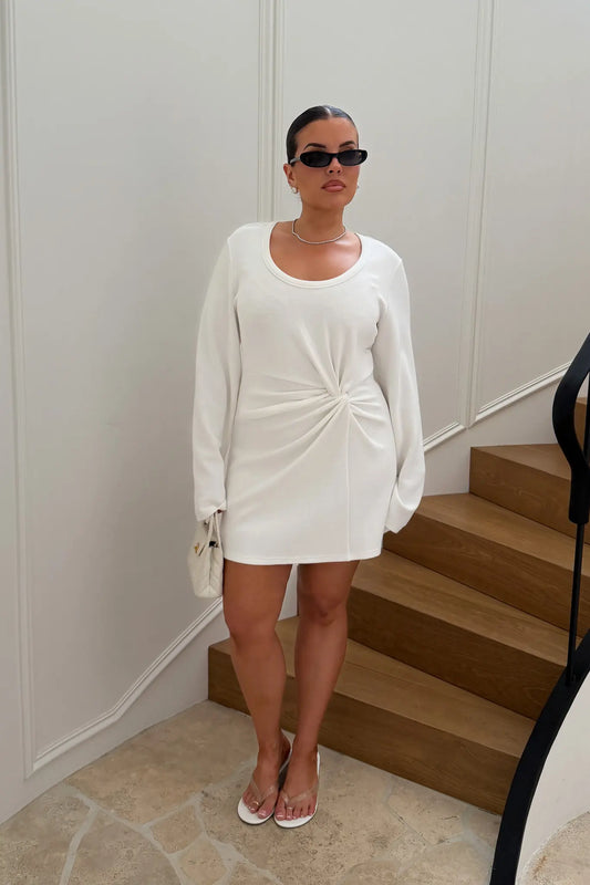 Jaz Long Sleeve Knot Mini Dress in White with a soft front knot, sculpted waist, and gentle ruching that creates a smooth, body hugging silhouette with a clean, elevated finish.