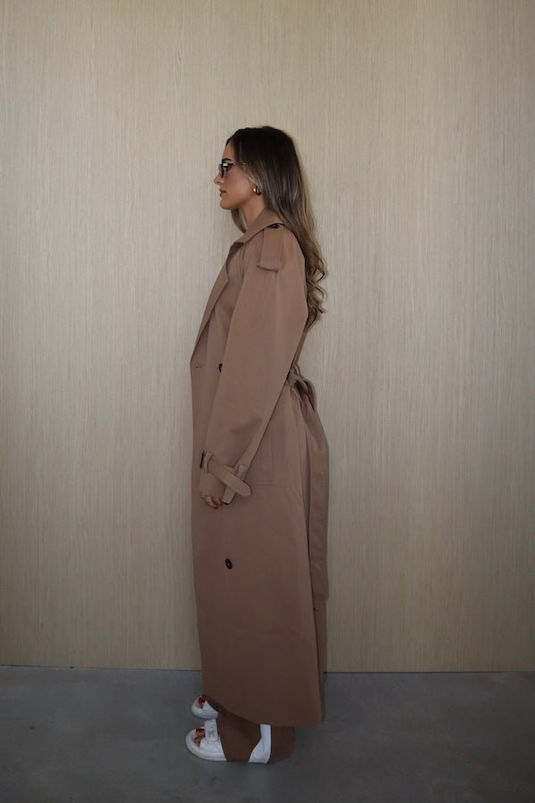 Trench Coat Tan by Sneaky Link – A timeless oversized coat in rich tan polyester, featuring classic details and subtle snake embroidery. Perfect for stylish transitional days.