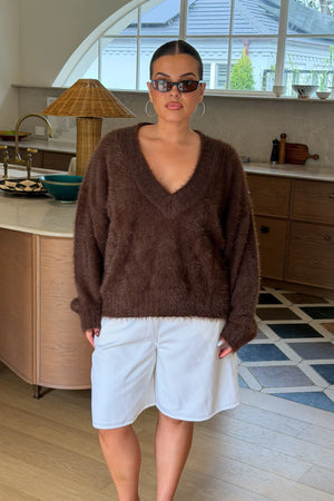 Jaz Fluffy V Neck Knit in Chocolate with a soft fluffy texture, relaxed fit, and deep V neckline creating a cosy, draped silhouette with a warm, elevated feel.