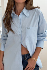 Boston Shirt Light Blue by Sneaky Link — Timeless oversized button-up in crisp cotton poplin with signature snake embroidery on the pocket. Classic, fresh, and versatile.