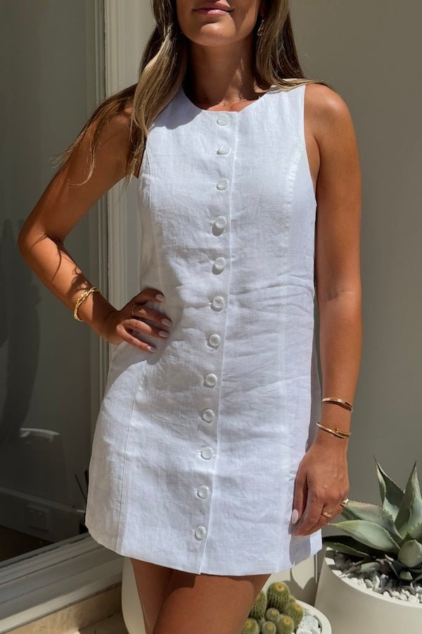 Mia Mini Dress White by Sneaky Link – A trendy, breathable linen dress with a high scoop neckline and button front, perfect for effortless summer days.