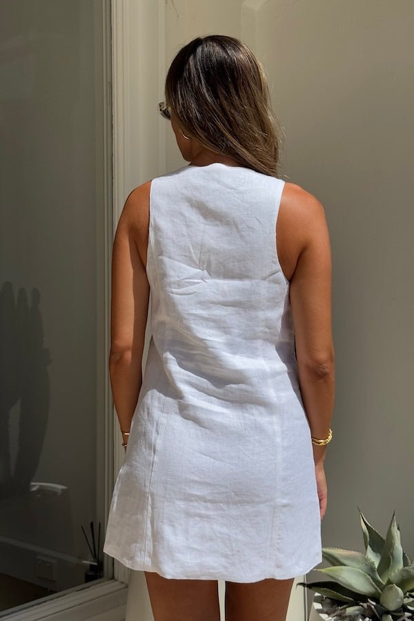 Mia Mini Dress White by Sneaky Link – A trendy, breathable linen dress with a high scoop neckline and button front, perfect for effortless summer days.