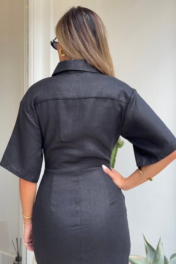 Lefka Midi Dress Black by Sneaky Link – A breathable 100% linen midi with button-front and flattering tucks, offering relaxed elegance perfect for sunny days and casual outings.