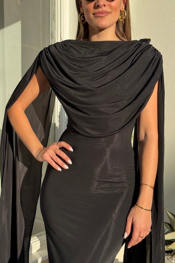Batista Basalto by Maygel Coronel – An elegant long dress with a cowl scoop neckline, flowing shoulder sashes, and a sleek column silhouette, perfect for sophisticated evening events and making a timeless, statuesque statement.