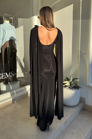 Batista Basalto by Maygel Coronel – An elegant long dress with a cowl scoop neckline, flowing shoulder sashes, and a sleek column silhouette, perfect for sophisticated evening events and making a timeless, statuesque statement.