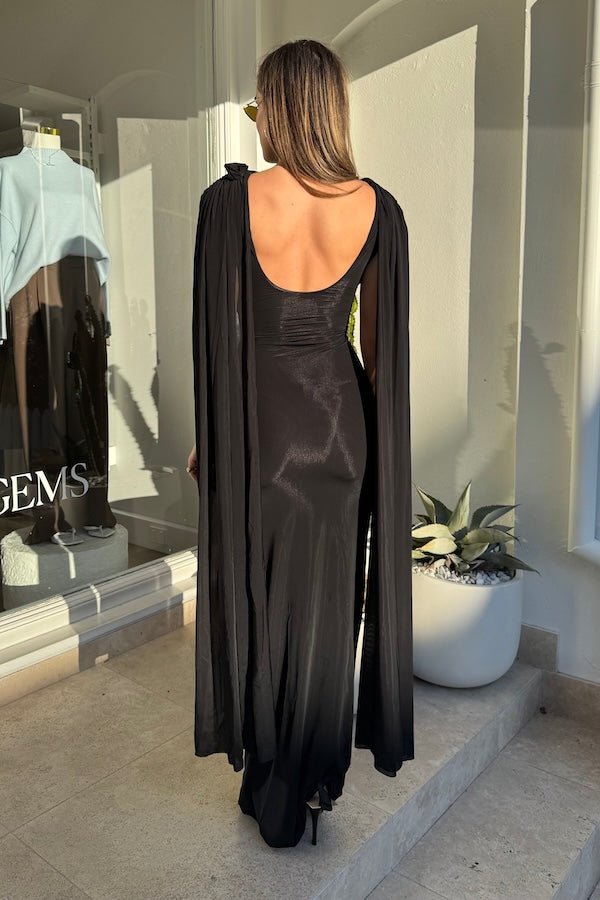 Batista Basalto by Maygel Coronel – An elegant long dress with a cowl scoop neckline, flowing shoulder sashes, and a sleek column silhouette, perfect for sophisticated evening events and making a timeless, statuesque statement.
