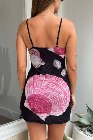 Ariel Mini Dress Black Shell by Sneaky Link – Trendy and flirty, this lightweight printed mesh mini features a custom hand-painted shell design, adjustable straps, and a flattering V-neckline, perfect for standout events with playful sophistication.