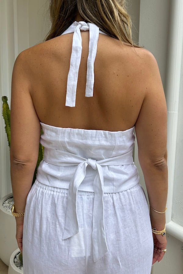 Luna Linen Vest White by Sneaky Link – Chic 100% linen halterneck vest with adjustable tie neck and back, elasticated detail, and front buttons, perfect for stylish summer layering with shorts, skirts, or denim.