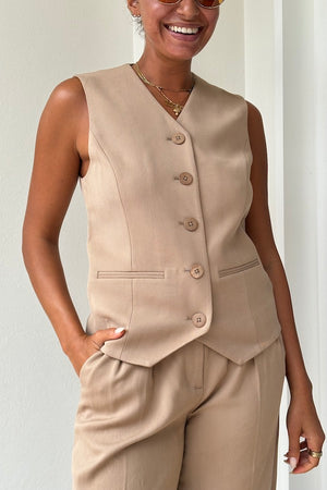 Devin Vest Tan by Rebecca Vallance – Tailored boxy vest with V neckline, shell buttons, and jet pockets. Fully lined for comfort. Fits true to size.