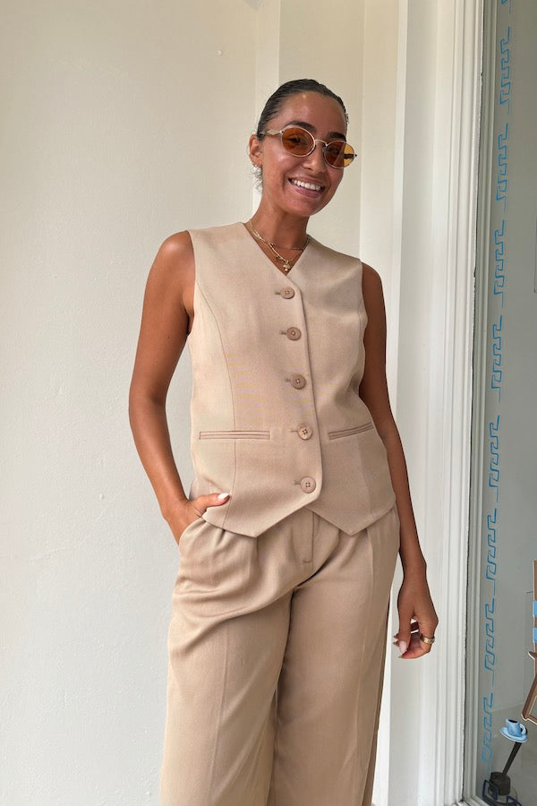 Devin Vest Tan by Rebecca Vallance – Tailored boxy vest with V neckline, shell buttons, and jet pockets. Fully lined for comfort. Fits true to size.