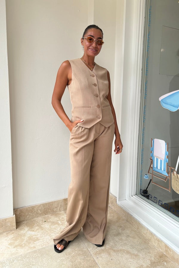 Devin Vest Tan by Rebecca Vallance – Tailored boxy vest with V neckline, shell buttons, and jet pockets. Fully lined for comfort. Fits true to size.