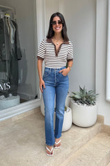 The Tripper Ankle Work Hard Play Hard by MOTHER, trendy high-rise jeans with a button fly and ankle-length hem. Perfect for both work and play, featuring a versatile mid-blue wash with whiskering and knee fading.