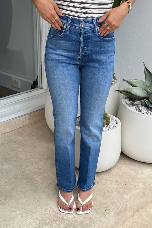 The Tripper Ankle Work Hard Play Hard by MOTHER, trendy high-rise jeans with a button fly and ankle-length hem. Perfect for both work and play, featuring a versatile mid-blue wash with whiskering and knee fading.