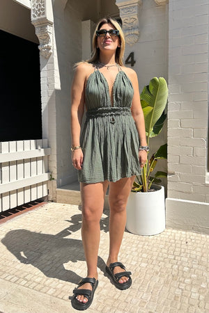 Lefkothea Mini Dress Khaki by D'Artemide – One-size cotton mini with halter tie, deep V neckline, low back, and side cutouts.