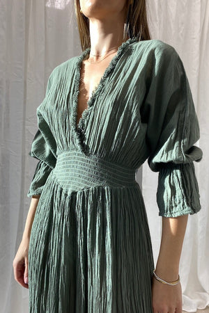 Eleni Dress Khaki by D'Artemide – One-size cotton dress with ruched waist, V neckline, and maxi skirt for chic all-day wear.