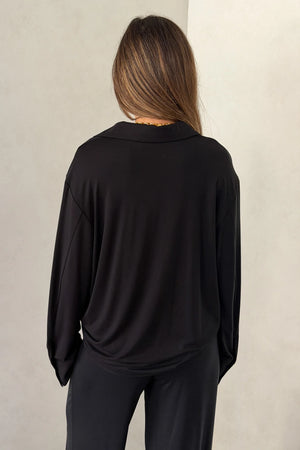 The Hunter Long Sleeve Polo Top in Black by Sneaky Link is a soft second skin essential with a flattering fit, polished collar, and easy everyday appeal.