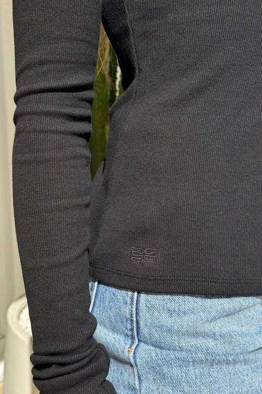 Lottie Long Sleeve Top Black by Sneaky Link – Soft cotton blend top with scoop neckline and snap button detail. Perfect for chic layering and viral winter style.