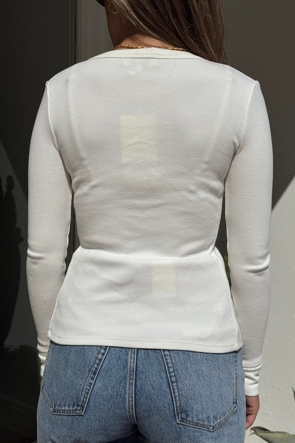 Lottie Long Sleeve Top White by Sneaky Link – Soft cotton blend with scoop neckline and snap button detail. Perfect for chic layering and viral winter style.