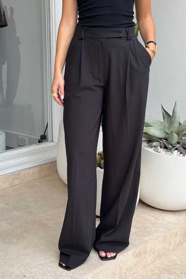 Kate Tailored Pant Black by Sneaky Link, high-waisted wide-leg pants crafted from luxe suiting fabric. Features waist tucks, pockets, and crossed belt loops for a modern, polished look.