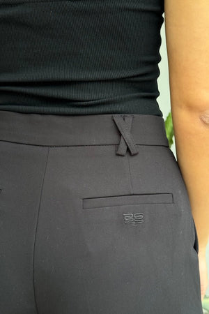 Kate Tailored Pant Black by Sneaky Link, high-waisted wide-leg pants crafted from luxe suiting fabric. Features waist tucks, pockets, and crossed belt loops for a modern, polished look.