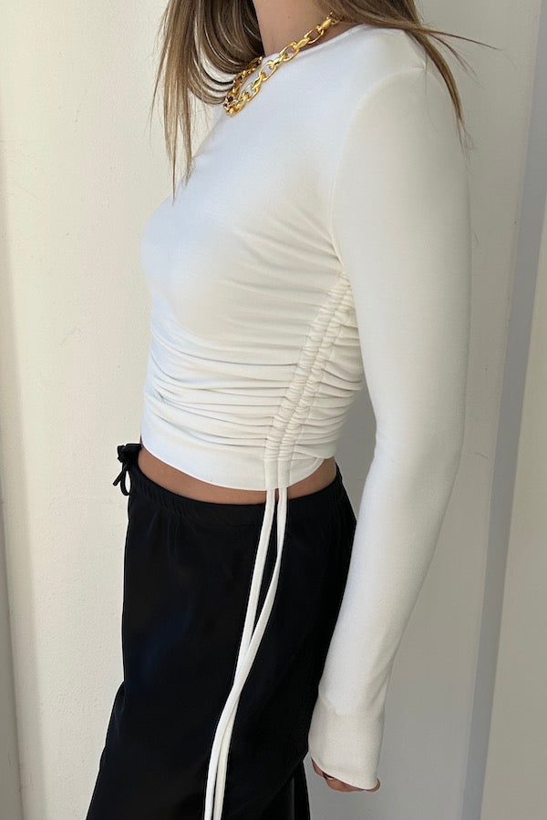 Lumi Cropped Top White by Sneaky Link – Soft bamboo blend long sleeve with adjustable tie sides and thumbholes, offering versatile cropped or full-length styling for effortless sophistication.
