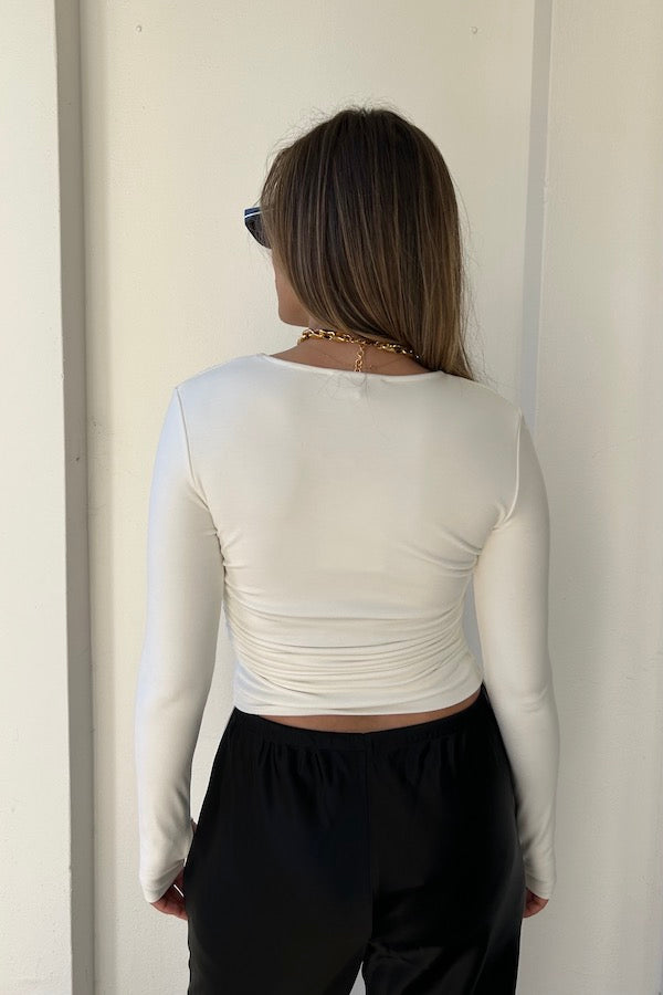 Lumi Cropped Top White by Sneaky Link – Soft bamboo blend long sleeve with adjustable tie sides and thumbholes, offering versatile cropped or full-length styling for effortless sophistication.