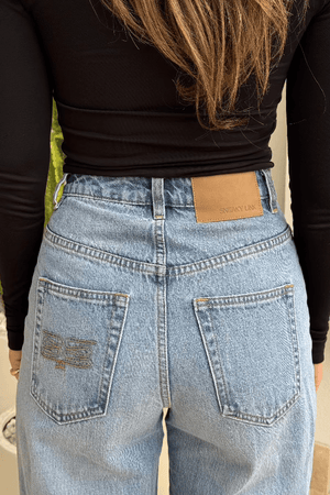 Stella High Rise Straight Leg Light Blue by Sneaky Link, classic high-waist jeans with a straight leg silhouette. Made from 100% cotton with signature SL Snake embroidery. Rigid fit; size up if between sizes. Cold delicate wash.