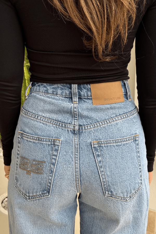 Stella High Rise Straight Leg Light Blue by Sneaky Link, classic high-waist jeans with a straight leg silhouette. Made from 100% cotton with signature SL Snake embroidery. Rigid fit; size up if between sizes. Cold delicate wash.