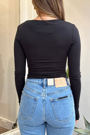 Daisy Long Sleeve Top Black by Sneaky Link – A cozy yet flirty top made from ultra-soft modal-spandex, featuring long sleeves, a V-neckline, and adjustable drawcord for a polished look.