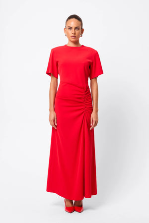 Infusion Maxi Dress in Red by Mossman, a refined crew-neck maxi with asymmetric ruching and fluid drape for effortless day-to-evening elegance.