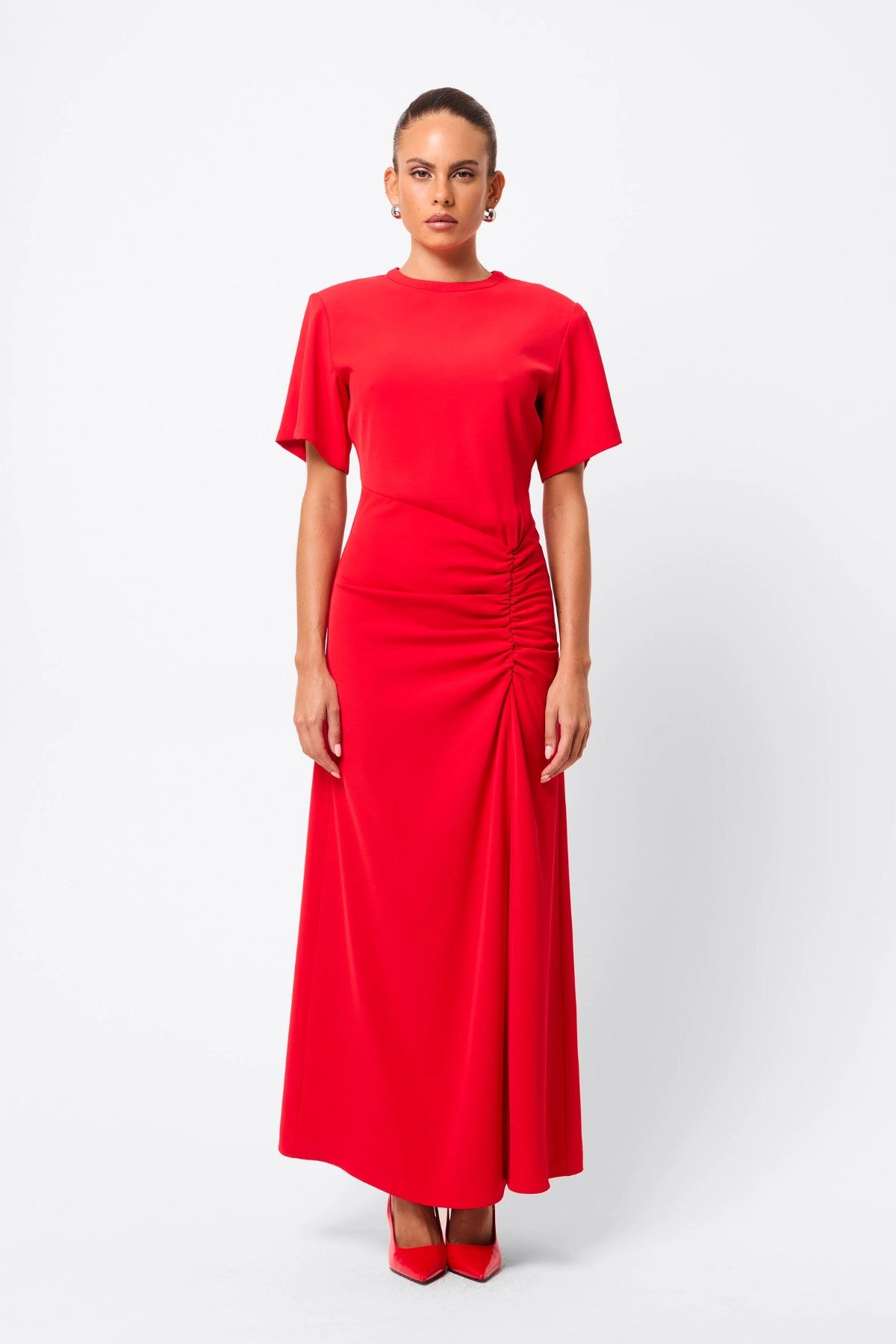 Infusion Maxi Dress in Red by Mossman, a refined crew-neck maxi with asymmetric ruching and fluid drape for effortless day-to-evening elegance.