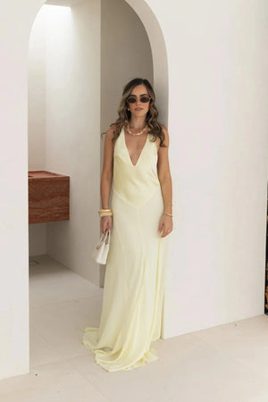 Jaz Hand V-Neck Maxi Dress in Butter by Sneaky Link, a flowing one-shoulder silhouette in soft yellow. Perfect for summer events or weddings.
