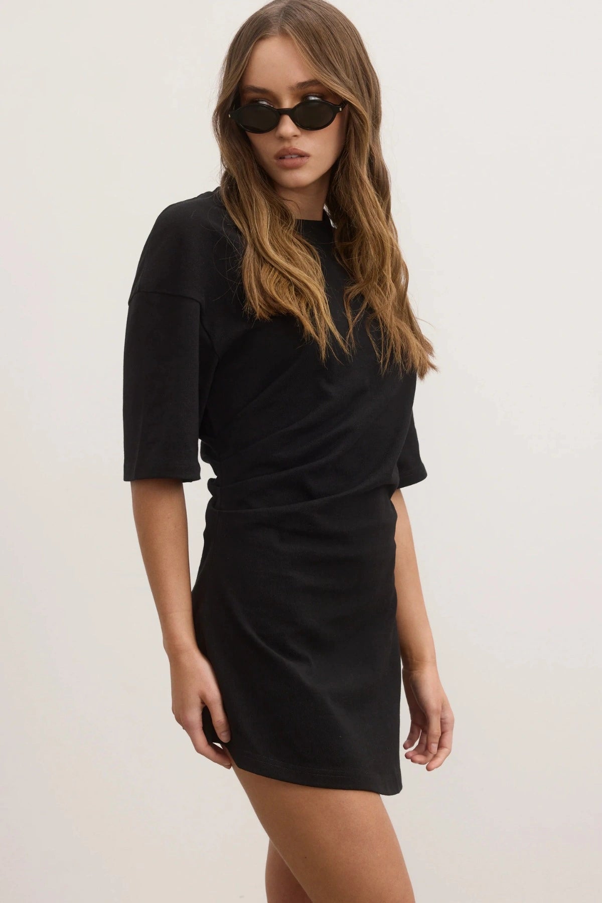 Joanna Dress in Black by Bayse, a relaxed cotton t-shirt dress with dropped shoulders and modern asymmetric hemline.